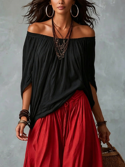 Conjunto de top negro con hombros descubiertos y pantalón de linterna amplio rojo