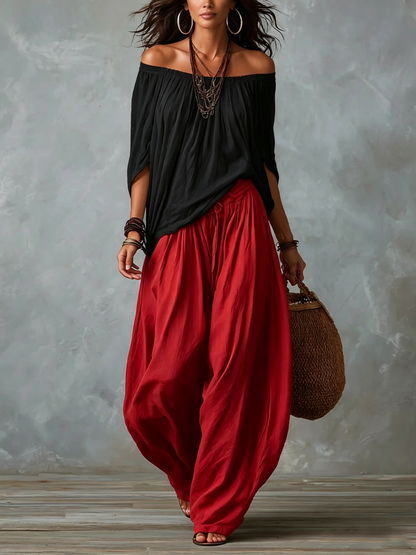 Conjunto de top negro con hombros descubiertos y pantalón de linterna amplio rojo
